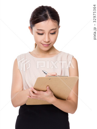 Asian Businesswoman write on clipboard Asian Businesswoman write on clipboard 32975364