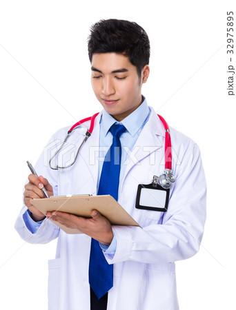 Young doctor take note on patient report 32975895