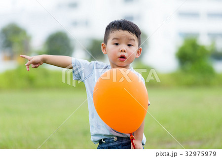 Little boy hold with balloon and finger point aside Little boy hold with balloon and finger point aside 32975979