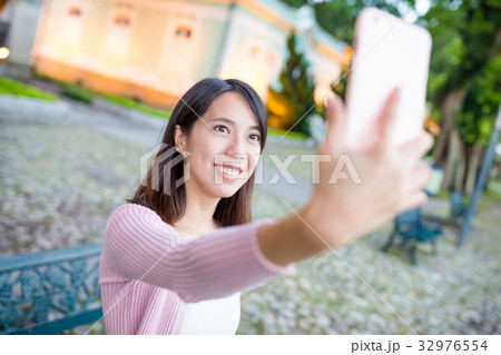 Woman taking selfie by mobile phone in Museu da Taipa 32976554