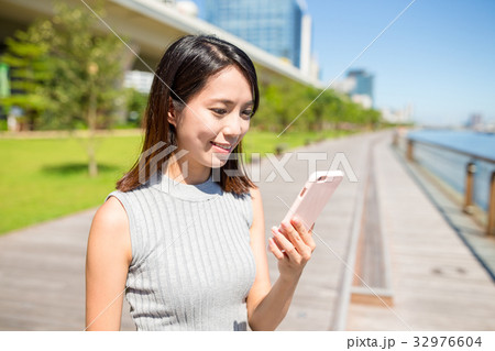 Woman looking at mobile phone Woman looking at mobile phone 32976604