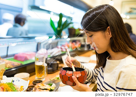 Woman having dinner in japanese restaurant 32976747