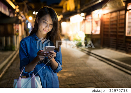 Woman use of mobile phone at night 32976758