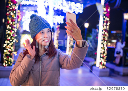Woman using mobile phone to take photo 32976850