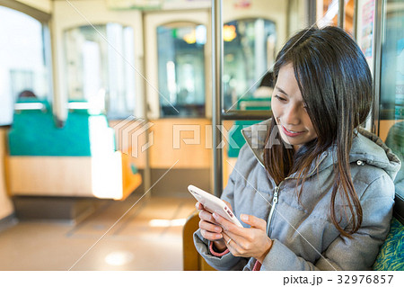 Woman working on cellphone in japanese train 32976857