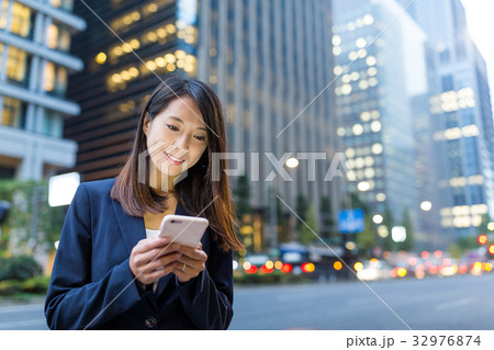 Businesswoman use of cellphone at Tokyo city Businesswoman use of cellphone at Tokyo city 32976874