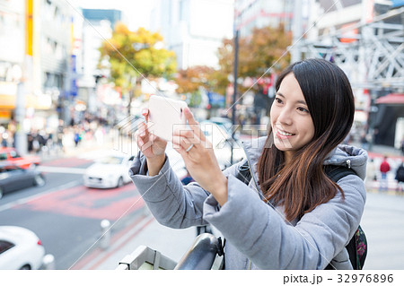 Woman capture photo by cellphone 32976896