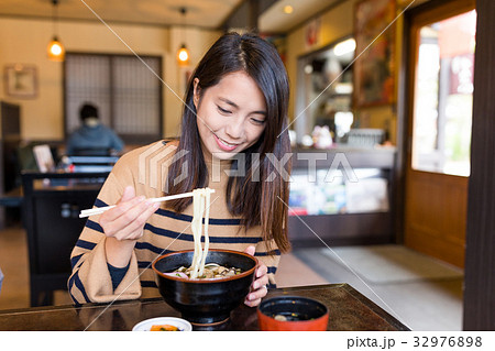 Young woman eating japanese udon in restaurant Young woman eating japanese udon in restaurant 32976898
