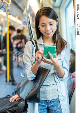 Woman listen to song on phone and taking the train 32977060