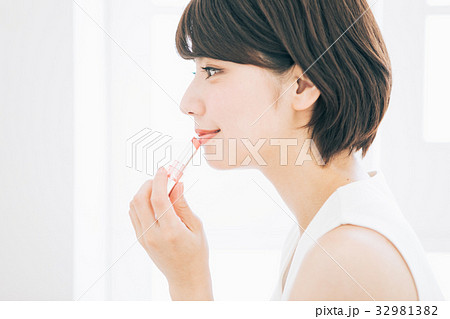 口紅を塗る女性の写真素材
