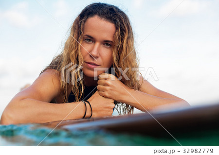 Surfer girl on surfboard have a fun before surfing Surfer girl on surfboard have a fun before surfing 32982779