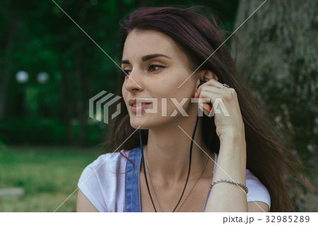 close up portrait of young brunette girl listening close up portrait of young brunette girl listening 32985289