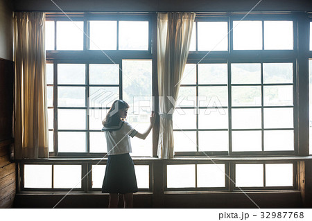 教室 窓から外を眺める女子高生の写真素材