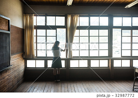 教室 窓を開ける女子高生の写真素材