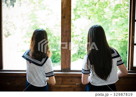 教室 窓から外を眺める女子高生の写真素材
