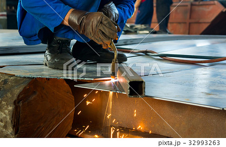 Man cutting metal with a welding cutting torch 32993263