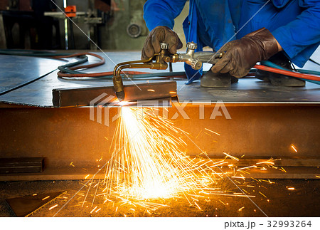 Man cutting metal with a welding cutting torch 32993264
