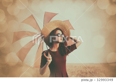 Girl in red dress with umbrella and hat 32993349