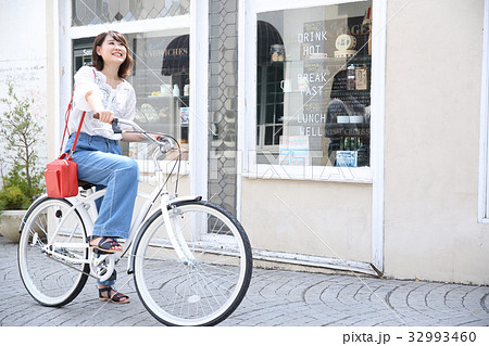 自転車で買い物する若い女性の写真素材