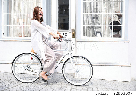 自転車で出かける女性の写真素材