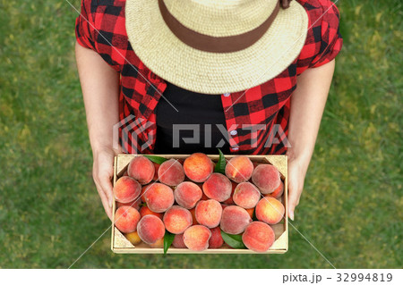 hands with crate of peaches 32994819