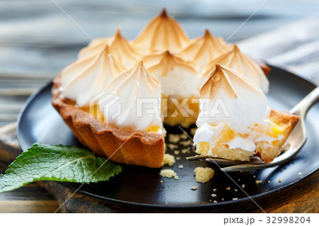 Chunk tartlets with meringue on a fork. Chunk tartlets with meringue on a fork. 32998204