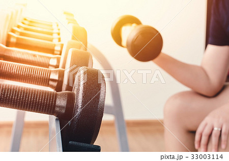 Hand of woman taking a dumbbell 33003114