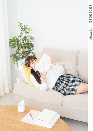 リビングでタブレットを見る女子高生 33005208