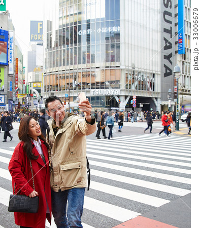 A picture of a couple taking photo together on a street 33006679