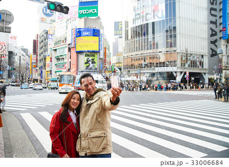 A man and his wife are taking photo together on a street 33006684