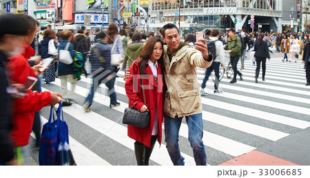 A picture of a couple taking photo on the street 33006685