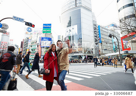 Two tourists are taking a selfie on the street Two tourists are taking a selfie on the street 33006687