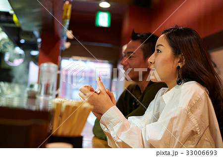 A man and his wife are sitting at a restaurant 33006693