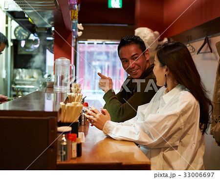 A man is pointing something to his wife at a restaurant A man is pointing something to his wife at a restaurant 33006697