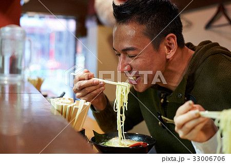 A man is eating ramen and smiling A man is eating ramen and smiling 33006706