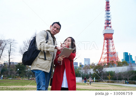 a girl is holding a tablet and pointing something for the man 33006759
