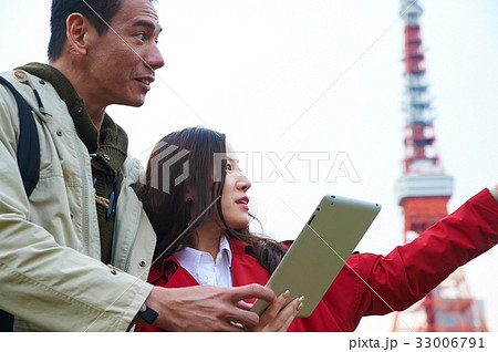 a woman is showing something to a man while holding tablet a woman is showing something to a man while holding tablet 33006791
