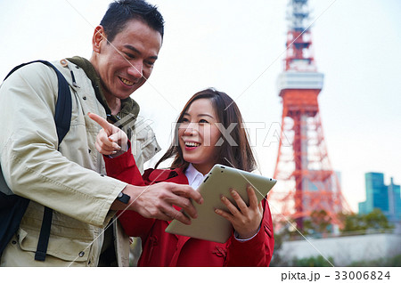 A couple is smiling when looking at their digital tablet A couple is smiling when looking at their digital tablet 33006824