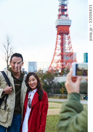 Two happy people are posing in front of Tokyo tower 33006835