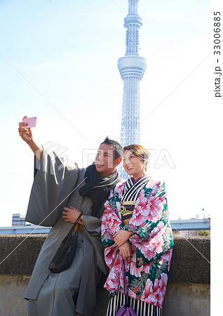 young couple is taking picture of themselves with mobile phone 33006885