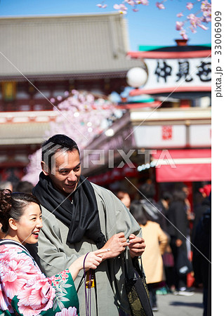 A woman is laughing and pointing something to a man at downtown in japan A woman is laughing and pointing something to a man at downtown in japan 33006909