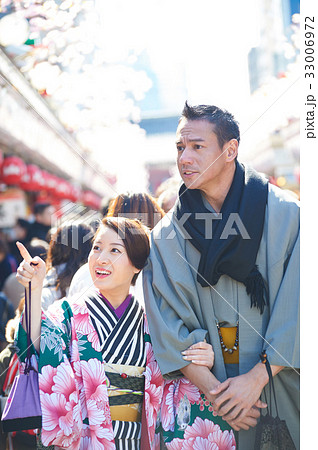 A young couple in kimono is walking happily outside. 33006972