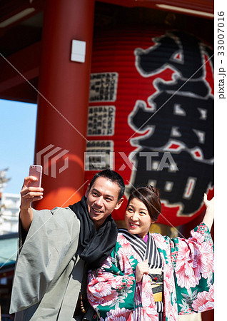A woman is posing while taking selfie with her husband. 33007016