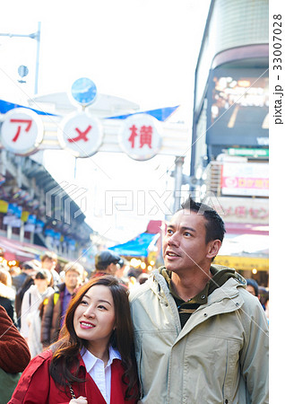 a photo of a happy couple looking at something on a street 33007028