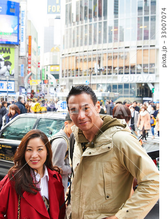two people are standing outside of the crowded street 33007074