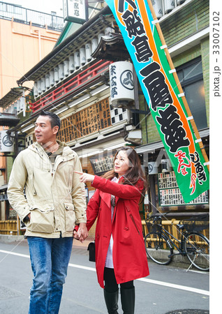 a girl is holding her boyfriend's hand and pointing at something a girl is holding her boyfriend's hand and pointing at something 33007102