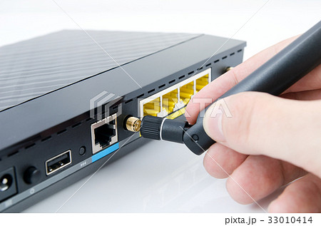 Man connecting antenna to Wi-Fi router Man connecting antenna to Wi-Fi router 33010414