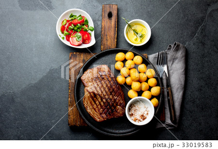 Grilled beef steak served on cast iron plate with 33019583
