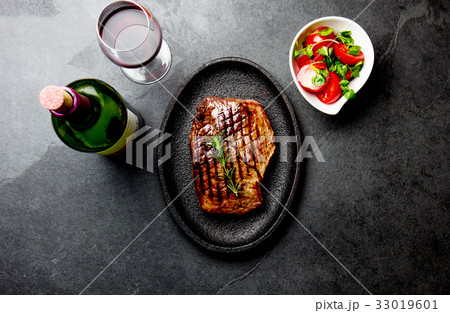 Grilled beef steak served on wooden table with 33019601
