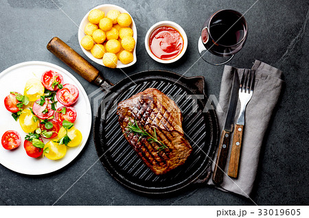 Grilled beef steak on grill pan served with tomato 33019605